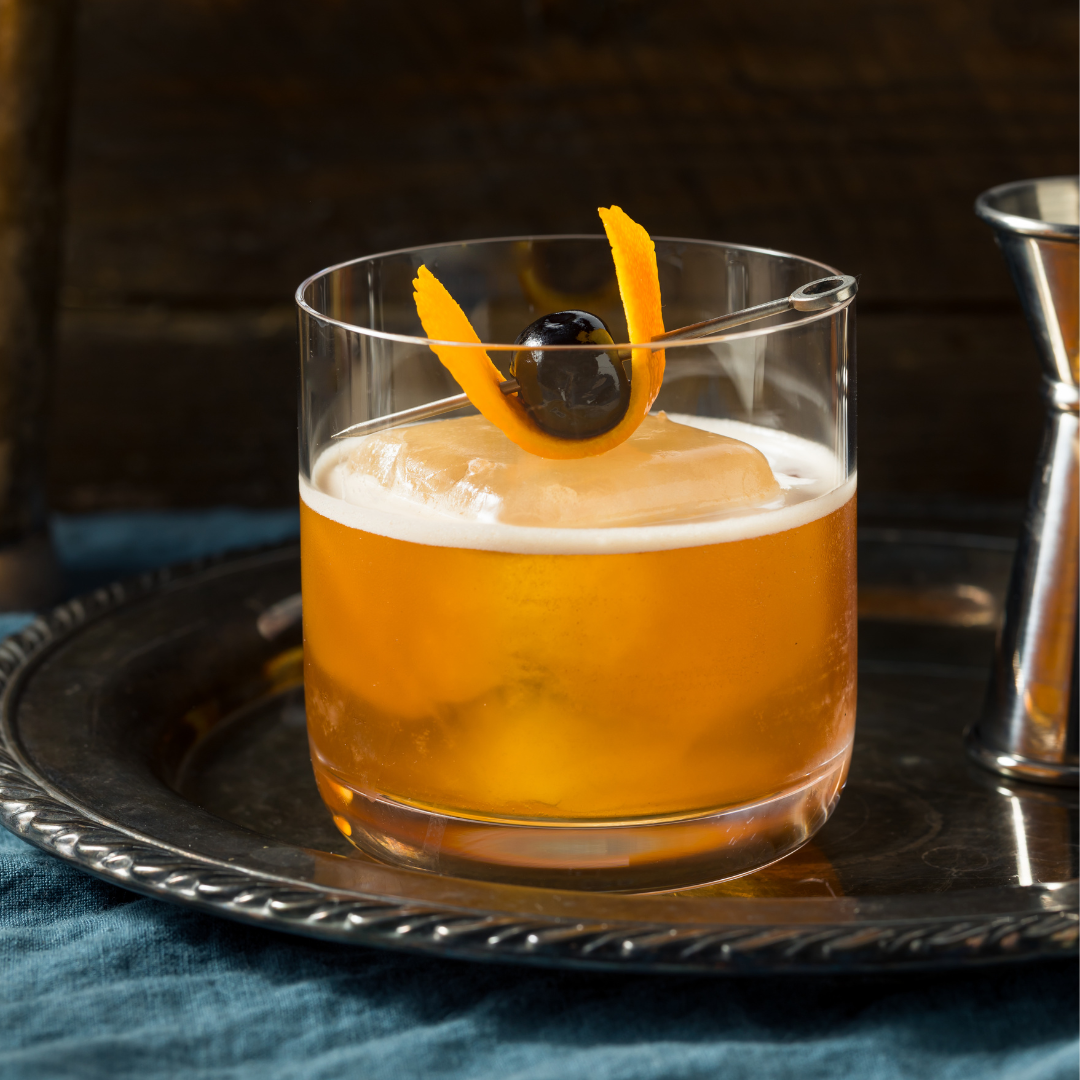 spiced old fashioned cocktail with orange slice and bourbon cherry garnish